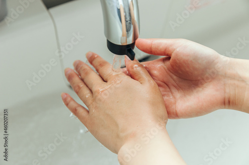 手を洗う女性 キッチンで手を洗う女性