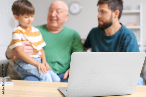 Happy man, his little son and father video chatting at home © Pixel-Shot