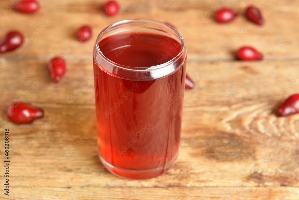 Glass of tasty dogwood drink on wooden background, closeup Glass of tasty dogwood drink on wooden background, closeup
