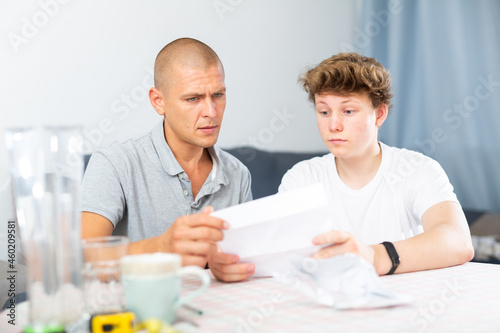 Father and son have recieved letter and reading it carefully.