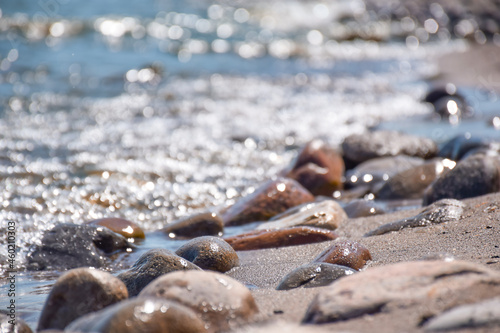 Seashore with rocks and bokeh sparkling blue water