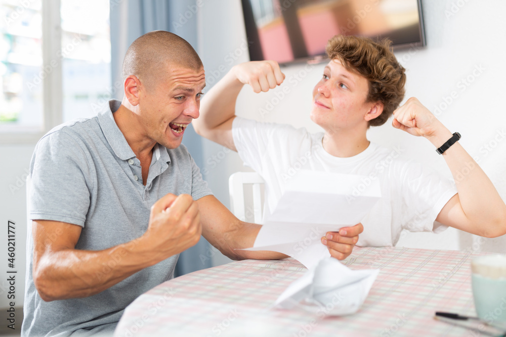 Obraz premium Joyful father and son cheering after reading a letter from college