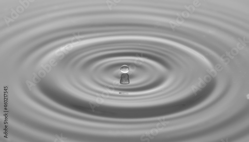 Water drop on water surface with grey light effects background.