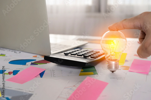 Concept of electricity charge, idea or light bulb and calculator on document.