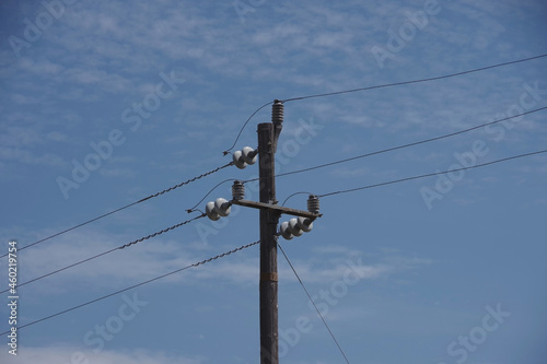 Simple rural electricity distribution pylon and power lines under blue sky