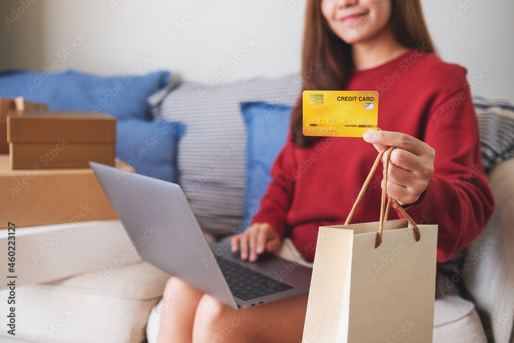 A woman using laptop computer and credit card for online shopping at home A woman using laptop computer and credit card for online shopping at home