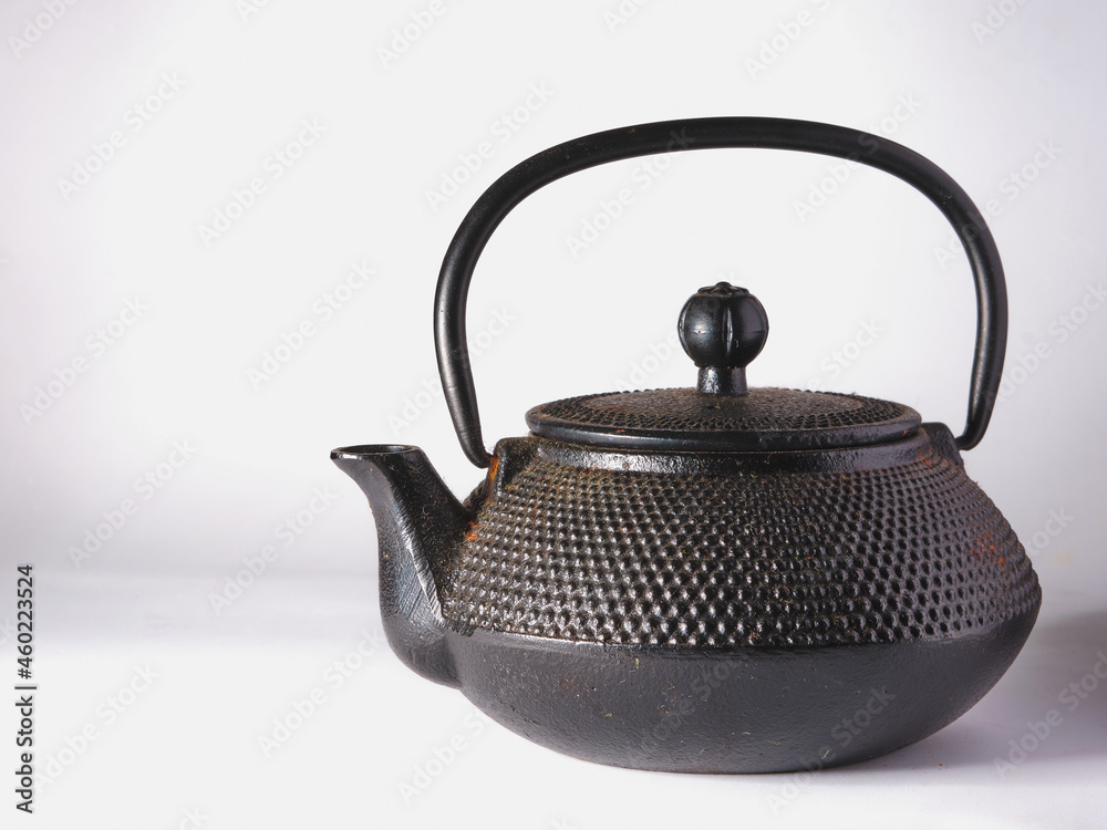 Black cast iron teapot on a white background. Black cast iron teapot on a white background.