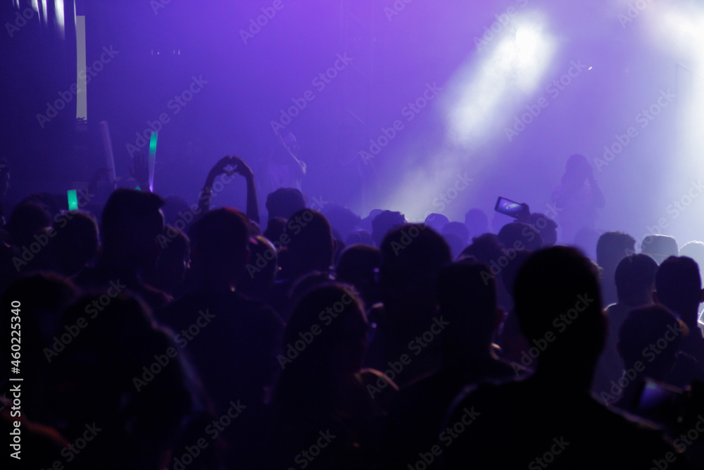 Fototapeta premium Silhouette of Crowd of people in concert with colorful lights in background. Concert concept