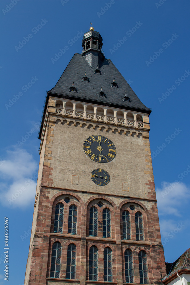 Close, upward view of Old Gate (Alpoertel), a medieval clock tower gate, in Speyer, Germany, with blue sky background.