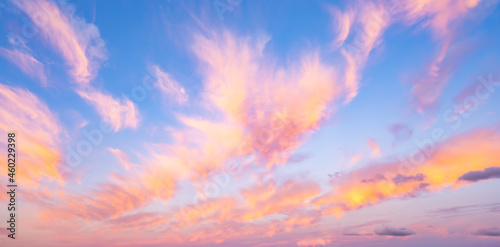 Obraz na płótnie Stunning romantic and relaxing sunrise with some pink illuminated clouds moving across a blue sky. Long exposure, natural background. w salonie