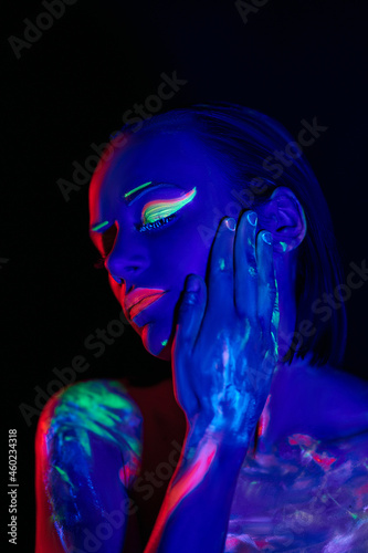 trendy neon makeup on the model. Woman with ultraviolet make-up. Disco night club chameleon. UV colors. Fashion of the future bright appearance. face Art. Copy space for text background