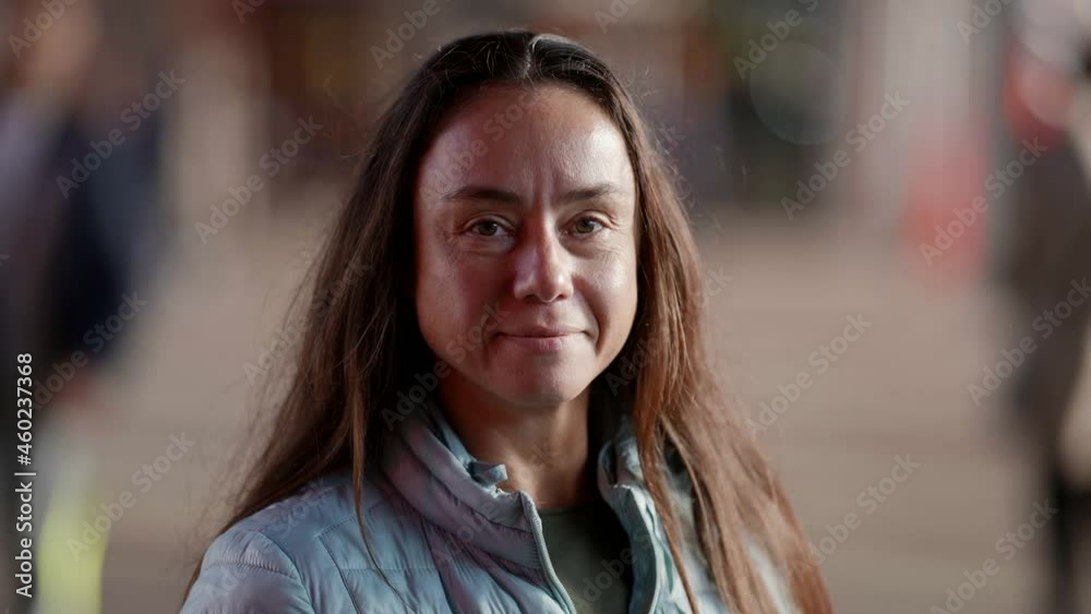 Smiling adult European woman looking at the camera outside on the street feels like a happy lady, rather slow movement Smiling adult European woman looking at the camera outside on the street feels like a happy lady, rather slow movement