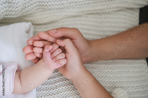 mothers hand hold little babys hand and daugthers hand. Happy family