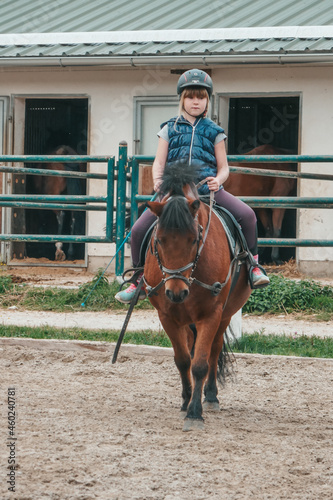 Little girl goes in for equestrian sports. The child is riding a horse.