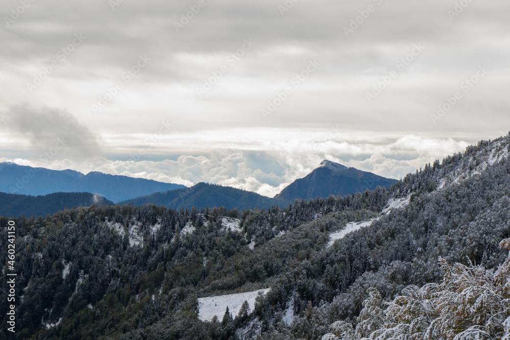 Winters mountain range landscape and view, snow and cloudy sky
