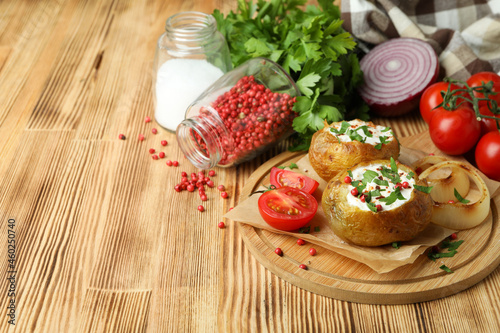 Concept of tasty food with baked potato on wooden table