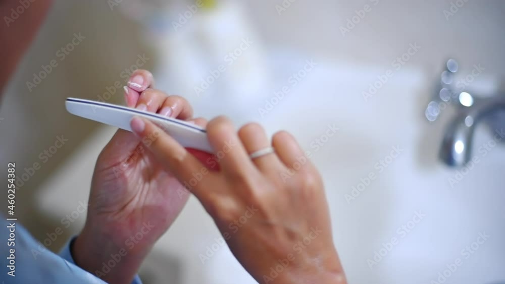 Woman polishing nails in the bathroom, slow motion Woman polishing nails in the bathroom, slow motion