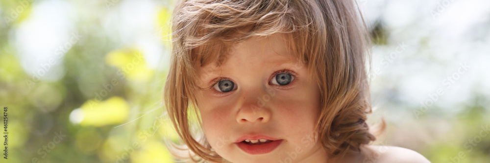 Happy little smiling child on a natural background walking in the park