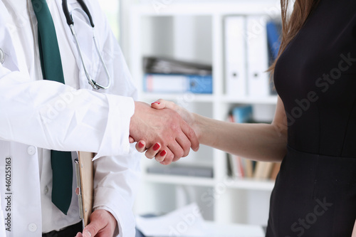 Doctor shake hand as hello with patient in office closeup