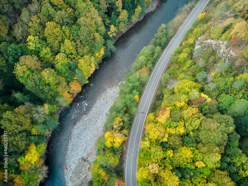 Aerial view of the road and colorful autumn forest with a mountain river in Russia, Adygea © ASHarchenko