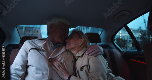 Happy mature couple embracing in backseat of car photo