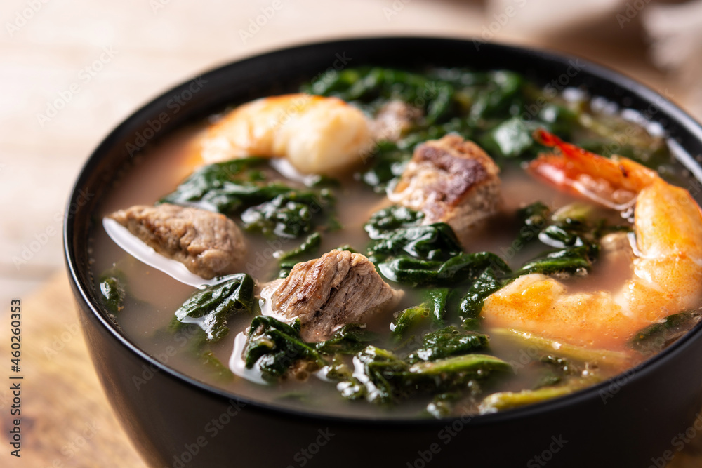Beef, okra stew and spinach soup in bowl on wooden table. Close up Beef, okra stew and spinach soup in bowl on wooden table. Close up
