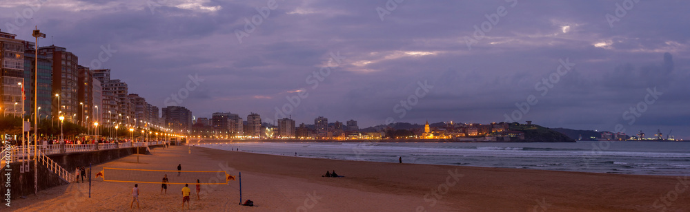 Vista panorámica de paseo y playa al anochecer en la ciudad de Gijón,  Asturias 