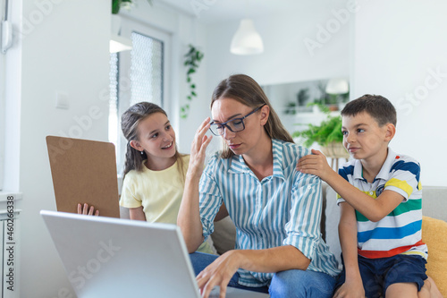 Slika na platnu Woman working from home during quarantine with her little son and daughter on co