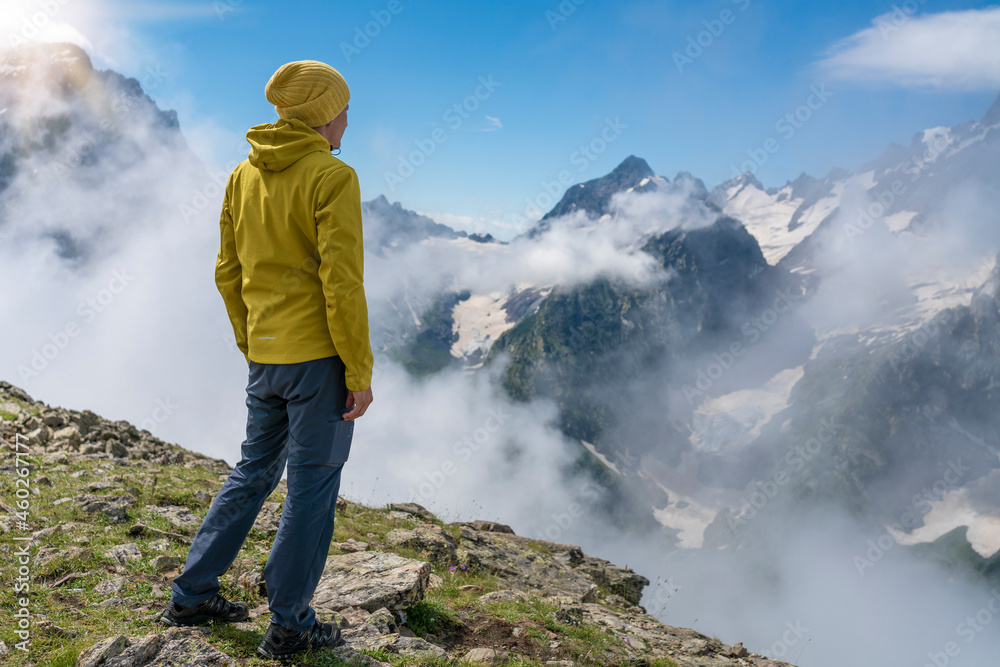 Tourist on the peak of high rocks. Sport and active life concept