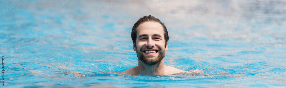 Cheerful man swimming in outdoor pool, banner Cheerful man swimming in outdoor pool, banner