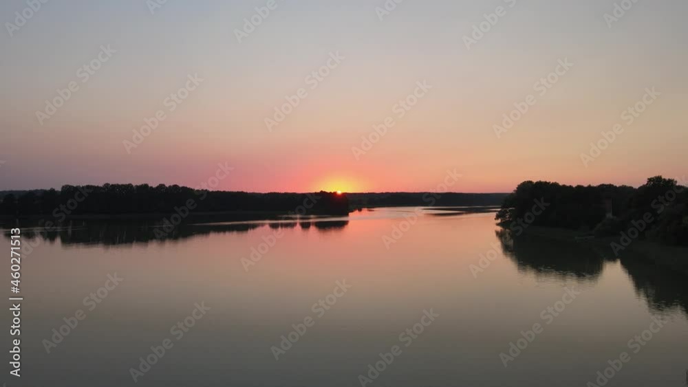 Beautiful Sunset of the Masurian Sea. Emerald green water surrounded by forests, autumn grass and passing clouds. Shoot with the drone Beautiful Sunset of the Masurian Sea. Emerald green water surrounded by forests, autumn grass and passing clouds. Shoot with the drone