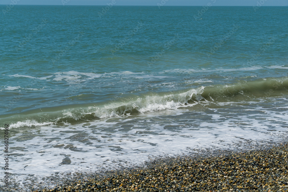 White wave breaking on Sochi Black Sea coast. White spray and foam in foreground. Emerald blue sea water as background for theme of relaxation. Elegant nature concept for design White wave breaking on Sochi Black Sea coast. White spray and foam in foreground. Emerald blue sea water as background for theme of relaxation. Elegant nature concept for design