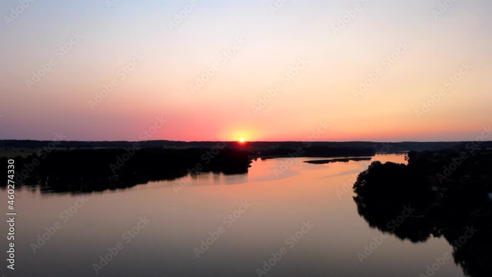 Beautiful Sunset of the Masurian Sea. Emerald green water surrounded by forests, autumn grass and passing clouds. Shoot with the drone Beautiful Sunset of the Masurian Sea. Emerald green water surrounded by forests, autumn grass and passing clouds. Shoot with the drone