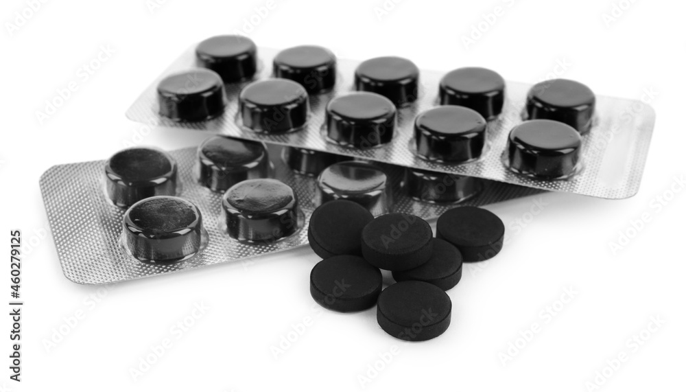 Activated charcoal pills on white background. Potent sorbent Activated charcoal pills on white background. Potent sorbent