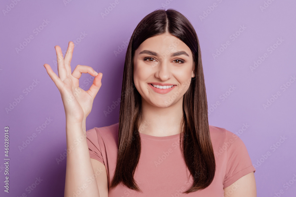 Photo of young attractive girl happy positive smile show okay alright sign isolated over violet color background Photo of young attractive girl happy positive smile show okay alright sign isolated over violet color background