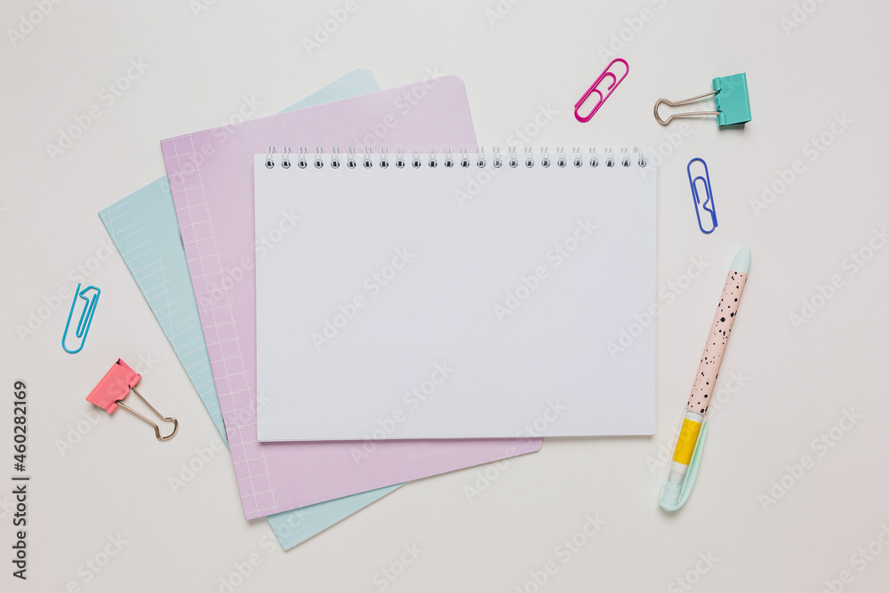Notepad, exercise book and pen on the desk. Mock up in copy space office on white background. Back to school Notepad, exercise book and pen on the desk. Mock up in copy space office on white background. Back to school