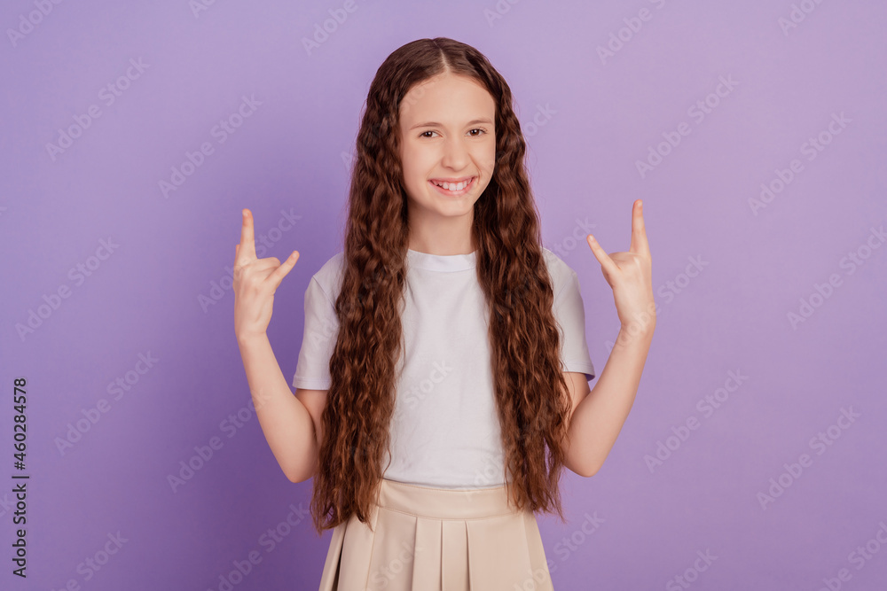 Photo of brown long haired girl make fingers rock symbol isolated on purple background Photo of brown long haired girl make fingers rock symbol isolated on purple background
