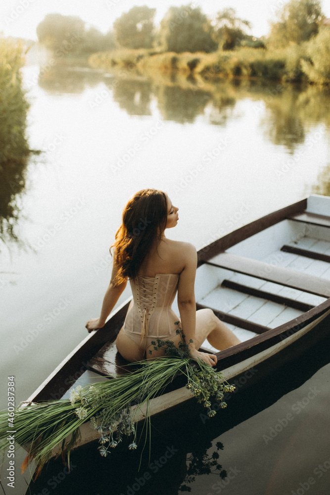 portraits of a girl in a boat on a lake in summer in beautiful lingerie