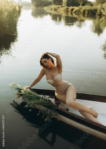 portraits of a girl in a boat on a lake in summer in beautiful lingerie