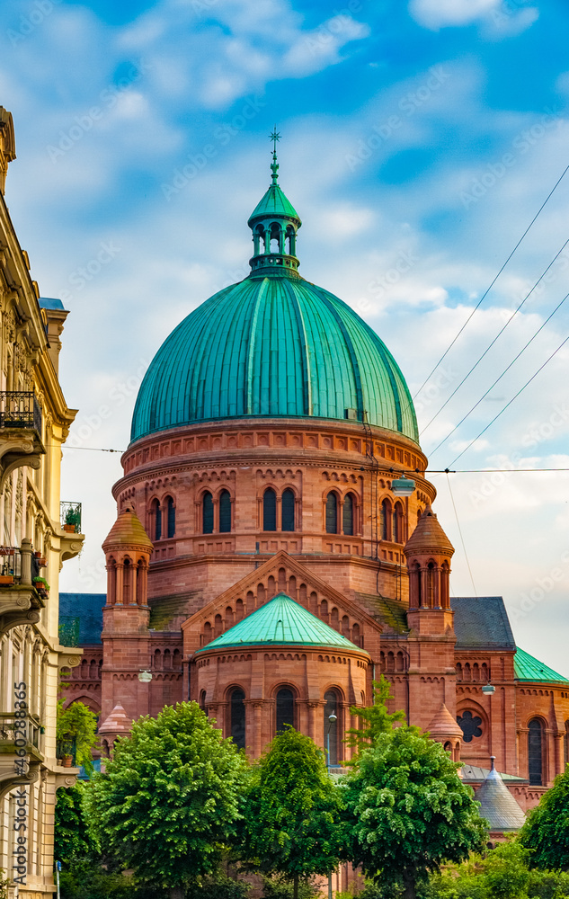 Great view of the late 19th-century Catholic church Saint-Pierre-le-Jeune, dedicated to Saint Peter in Strasbourg, France. It is crowned with a heavy and imposing dome.