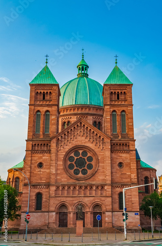 Lovely view of the Saint-Pierre-le-Jeune Catholic Church with its heavy and imposing dome in Strasbourg, France. The main facade, built with red rose sandstone, is flanked by two bell towers.