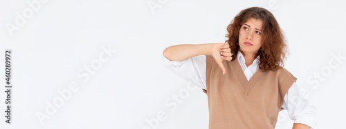 Dislike sign. Wrong choice. Portrait of disappointed skeptic woman disapproving with thumb down gesture isolated on white empty space background. No signal. Failure mistake.