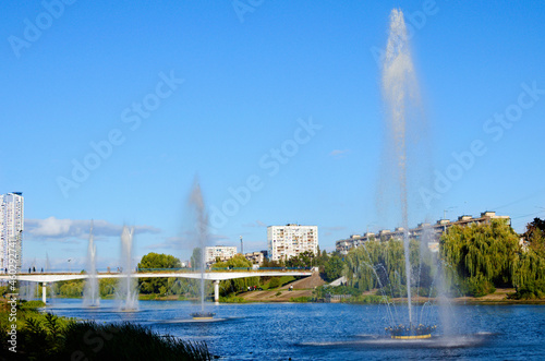 Picturesque autumn landscape of Rusanovka neighborhood at sunny day. Fountains in the city channel. Old skyscrapers in the background