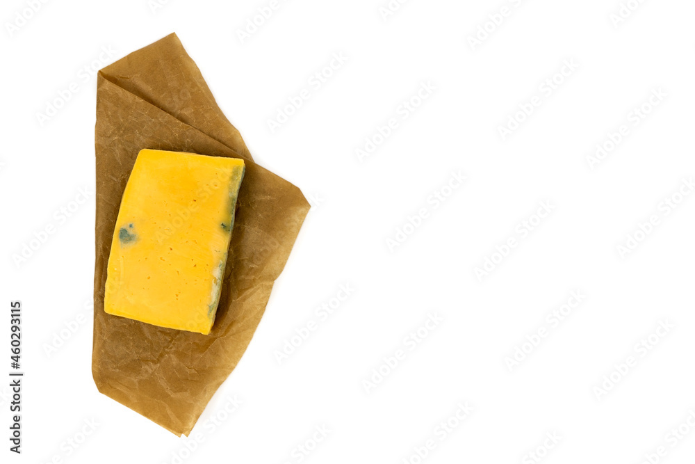Rectangular piece of moldy cheese on craft paper. Top view.