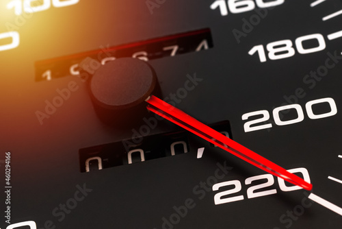 Car speedometer. Auto car speedometer shows 220 km h or miles.Closeup shot,dark black background.Automobile dangerous speed concept