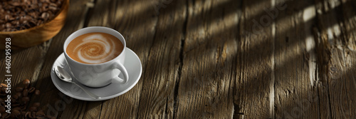 Frische Tasse Kaffee auf Tisch aus Holz mit Kaffeebohnen