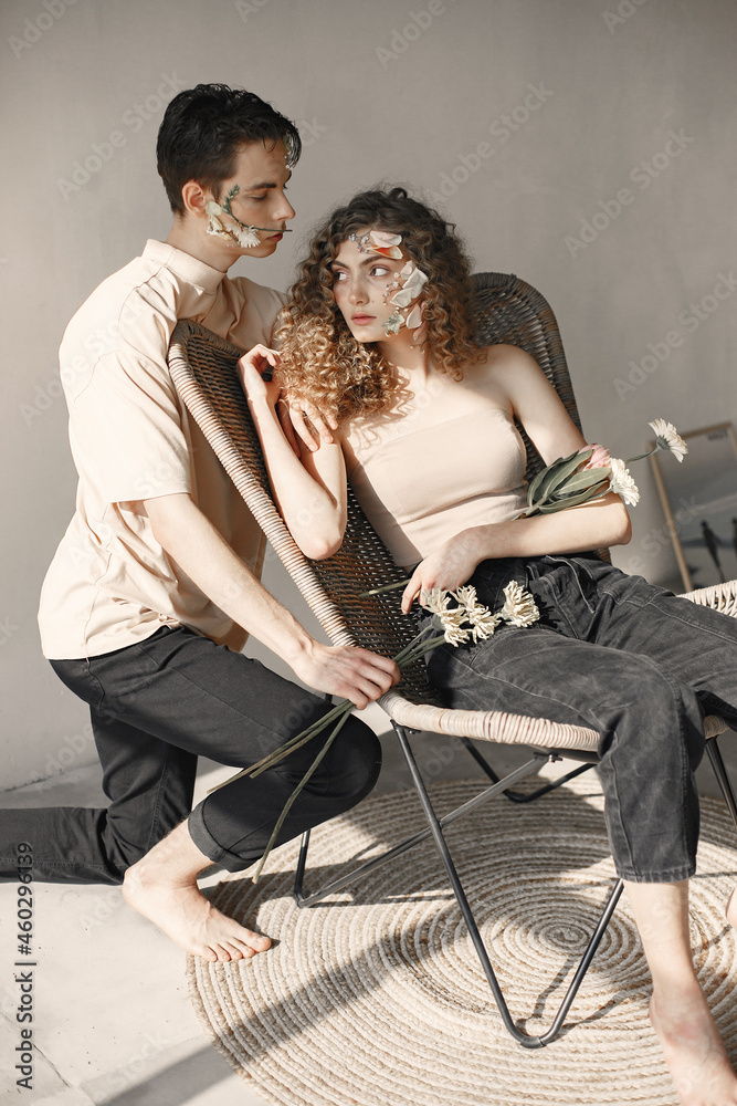 Emotional portrait of a boy and girl with flowers on their face