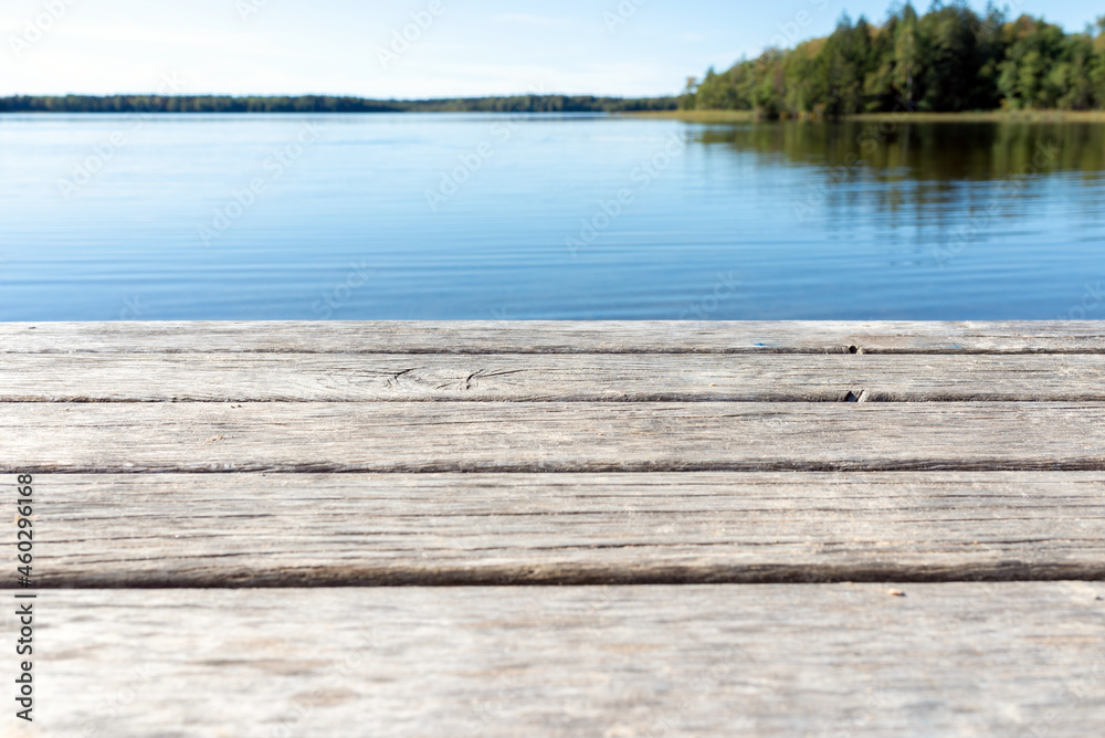 Naklejka premium Pier on the lake.Wooden bridge forest in spring autumn time with blue lake. Lake for fishing with pier.Copy space.
