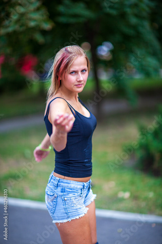 Young blonde happy girl resting in the park on a warm summer day photo