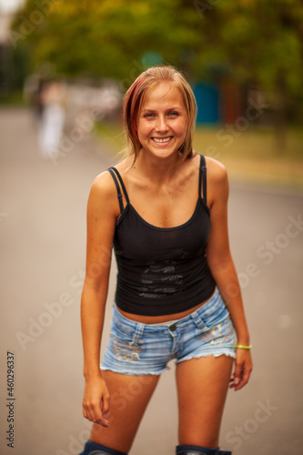 Young blonde happy girl resting in the park on a warm summer day photo